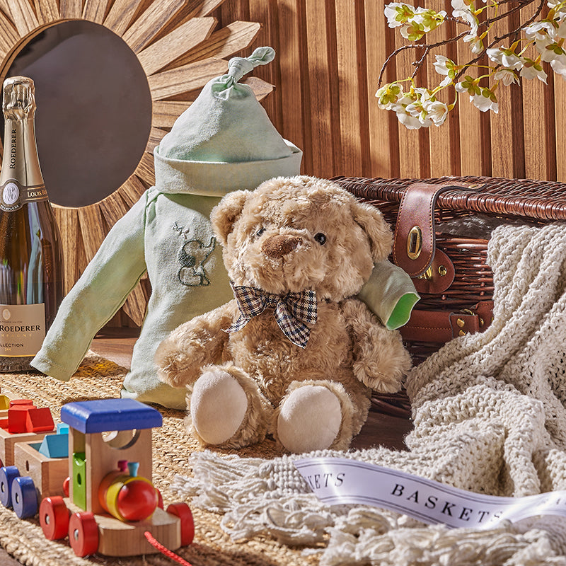 Teddy bare with baby boy clothes and a toy train